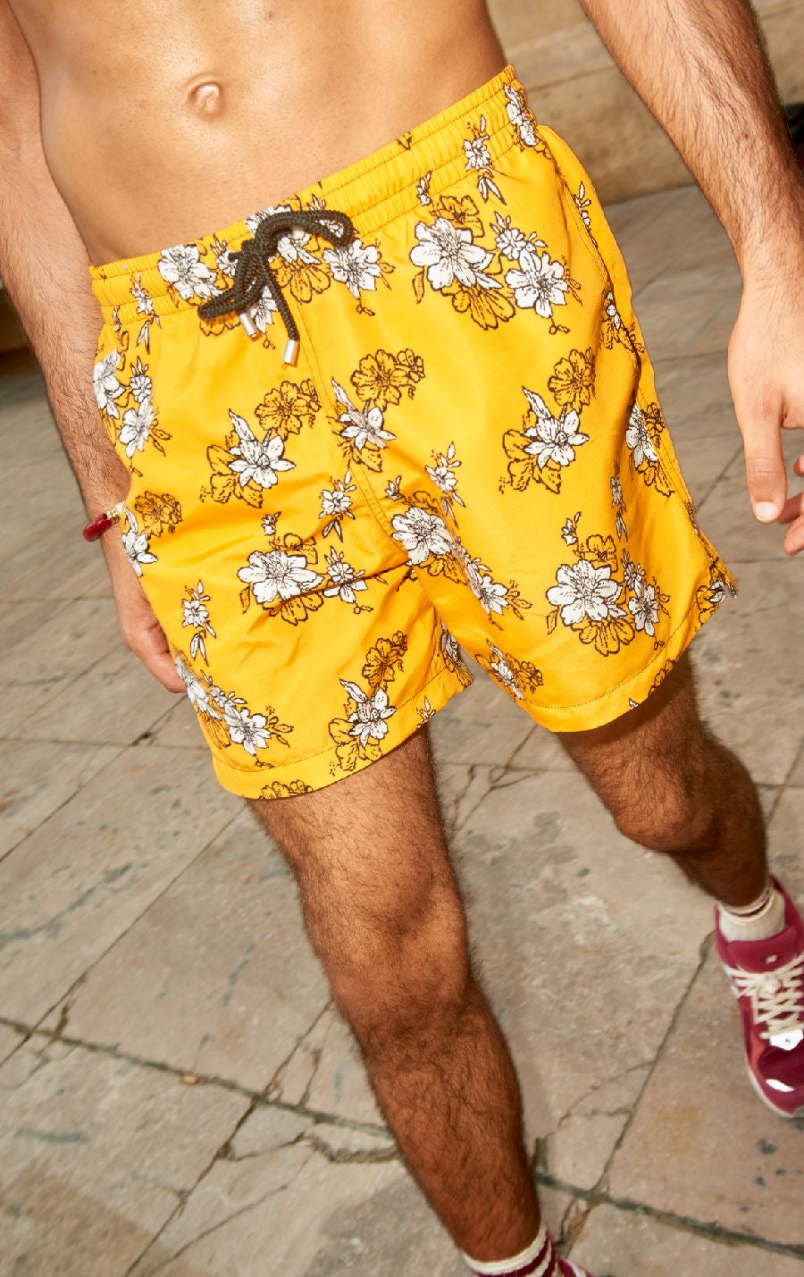 Photo rapprochée du short de bain jaune à fleurs.