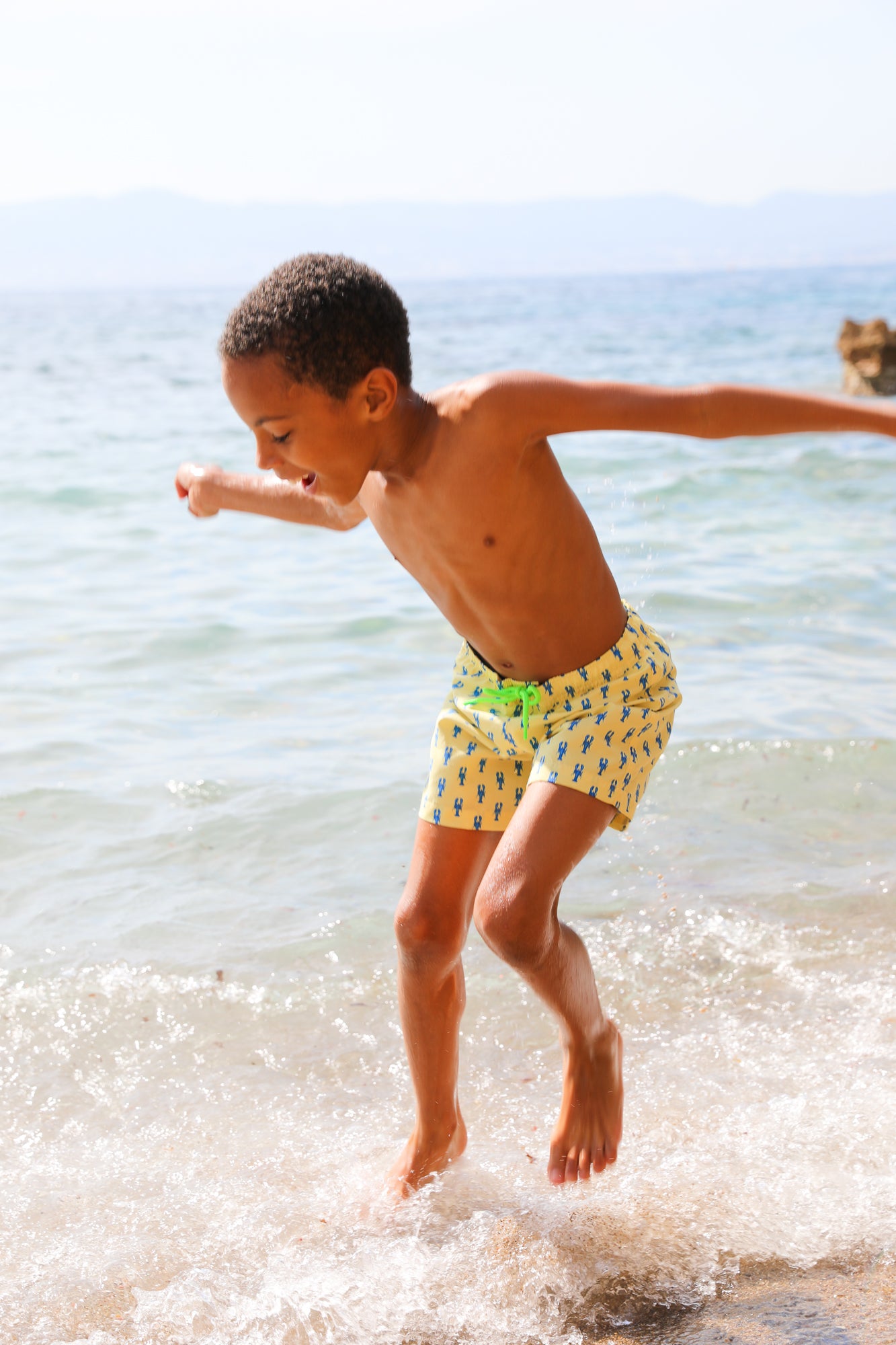 Photo d'un enfant à la plage portant le short de maillot de bain Jano Brai x Poolday