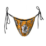 Photo détourée sur fond blanc du bas de maillot Alaior, imprimé de fleurs blanches sur fond jaune, avec les ficelles noires.