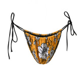 Photo détourée sur fond blanc du bas de maillot Alaior, imprimé de fleurs blanches sur fond jaune, avec les ficelles noires.