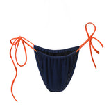 Photo détourée sur fond blanc du bas du maillot de bain Alaior en couleur bleu marine avec les ficelles oranges