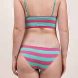 Photo de dos d'une femme portant le maillot de bain Andréas vert et framboise rayé
