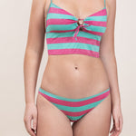 Photo de face d'une femme portant le maillot de bain deux pièces Andréas vert et framboise rayé