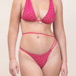 Photo d'une femme de face portant le maillot de bain deux pièces Bari de couleur fuschia avec du lurex.