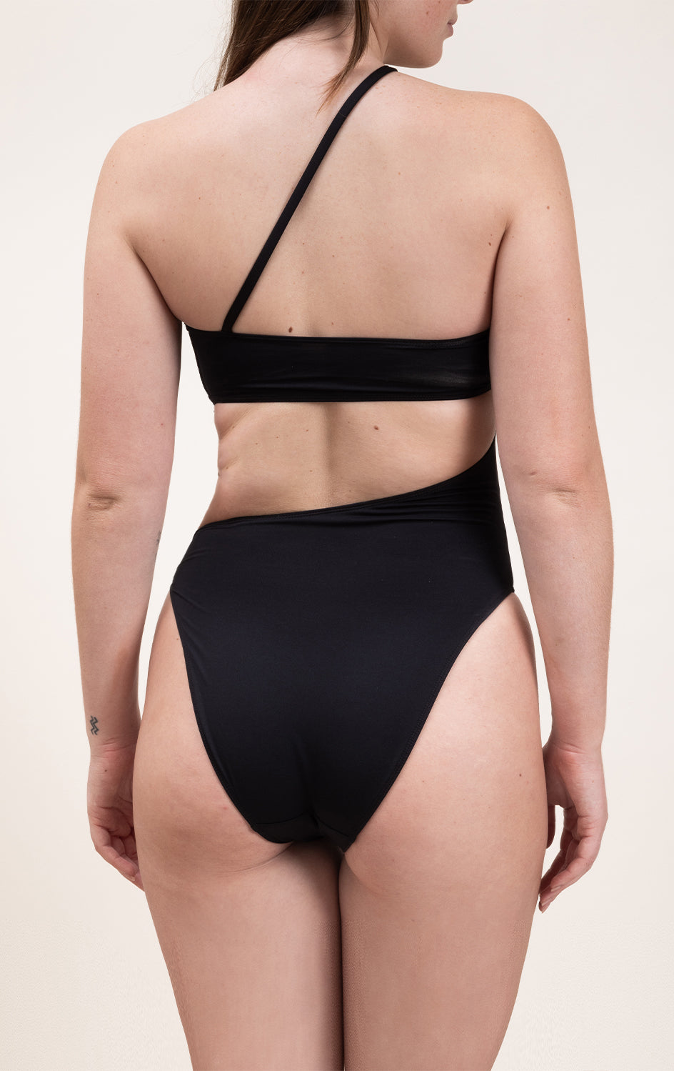 Photo d'une femme de dos portant le maillot de bain une pièce Capri noir