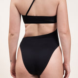 Photo d'une femme de dos portant le maillot de bain une pièce Capri noir