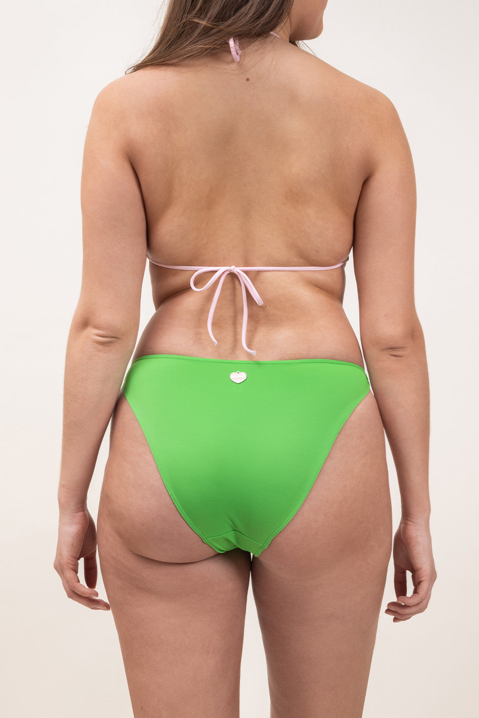 Photo de dos d'une femme portant le maillot de bain une pièce Donatella en couleur rose blush et vert matcha