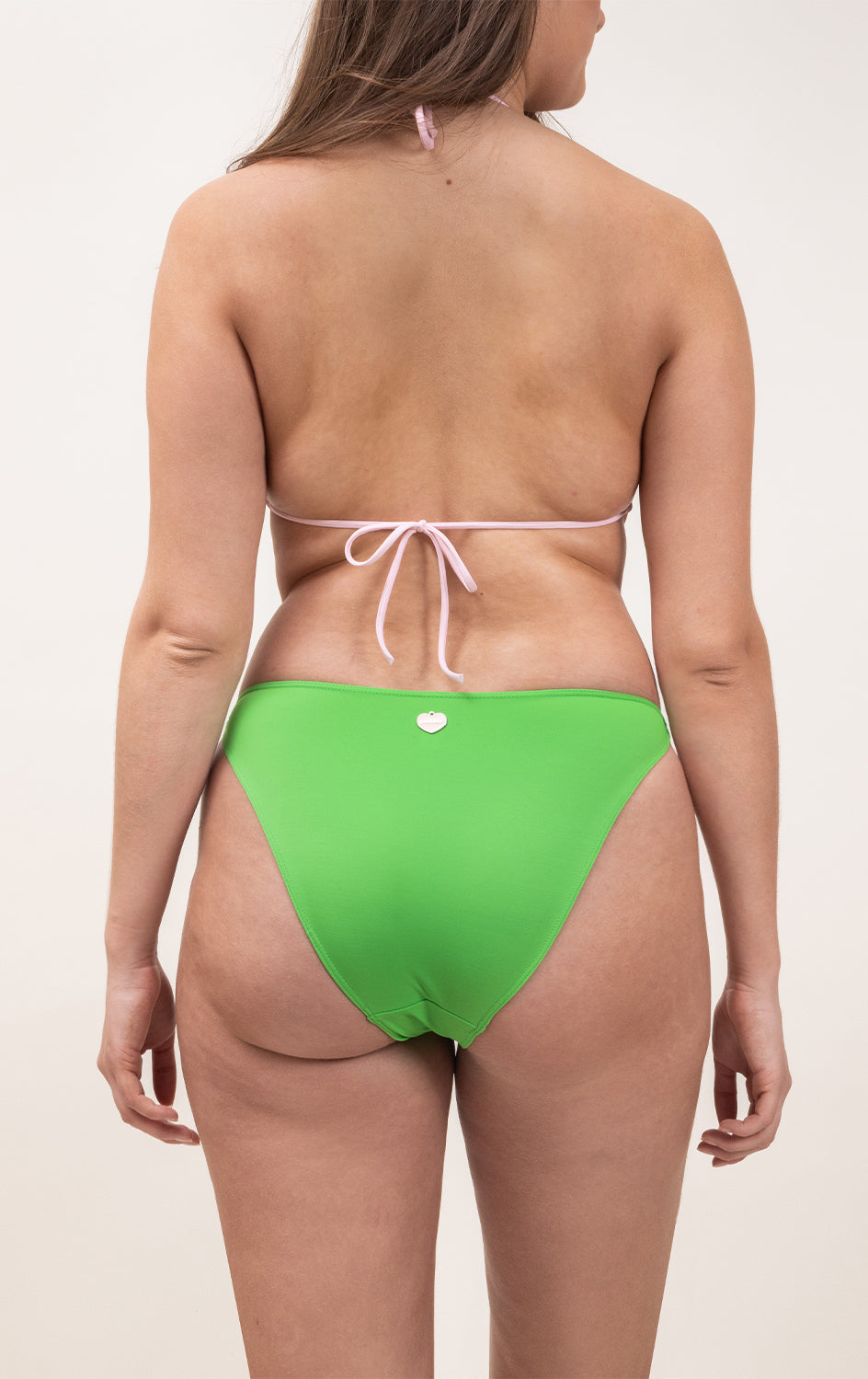 Photo de dos d'une femme portant le maillot de bain une pièce Donatella en couleur rose blush et vert matcha