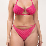 Photo d'une femme à forte poitrine de face  portant le haut de maillot de bain Ponza en fuschia/lurex