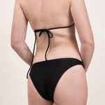 Photo d'une femme de dos portant le bas de maillot de bain Serena en noir jacquard