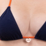 Photo rapprochée de face d'une femme portant le haut de maillot de bain Talita en tangerine et matière éponge