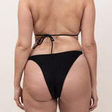 Photo de dos d'une femme portant le haut de maillot de bain Talita en noir jacquard