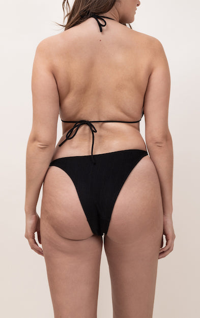 Photo de dos d'une femme portant le haut de maillot de bain Talita en noir jacquard