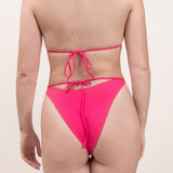 Photo d'une femme de dos portant le bas de maillot de bain Tiana en rose saphire