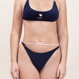 Photo d'une femme portant le haut de maillot de bain Lucia bleu marine et rose blush, en matière éponge, de face