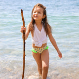 Photo d'une petite fille à la mer portant la culotte de maillot de bain Lolo avec des homards bleus et des froufrous verts sur les côtés