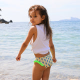 Photo d'une petite fille à la mer de dos portant la culotte de maillot de bain Lolo avec des homards bleus et des froufrous verts sur les côtés