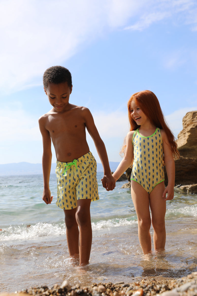 Photo de deux enfants à la plage portant le maillot de bain une pièce Albanita