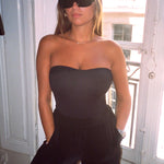 Photo d'une femme de face  portant le maillot de bain une pièce Cala Rossa noir avec un pantalon 
