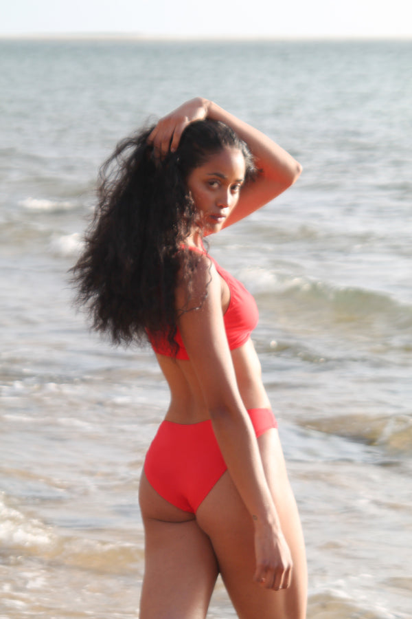 Photo de côté d'une femme à la plage portant le bas de maillot de bain Twin Palm rouge