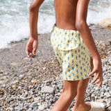 Photo de dos d'un enfant à la plage portant le short de maillot de bain Jano Brai x Poolday