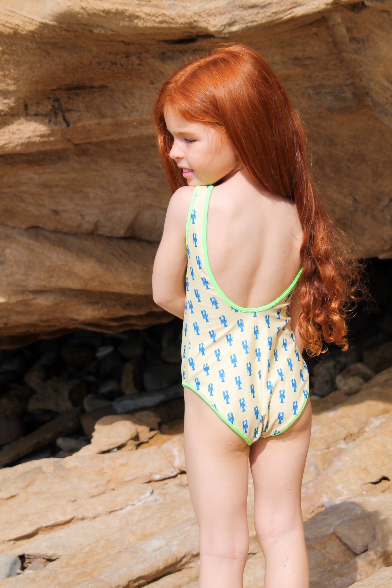 Photo de dos d'une enfant à la plage portant le maillot de bain une pièce Albanita