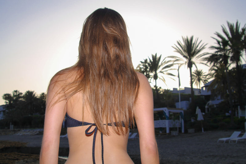 Photo de dos d'une mannequin portant le haut de maillot Amalfi noir rayé