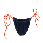 Photo détourée sur fond blanc du bas du maillot de bain Alaior en couleur bleu marine avec les ficelles oranges