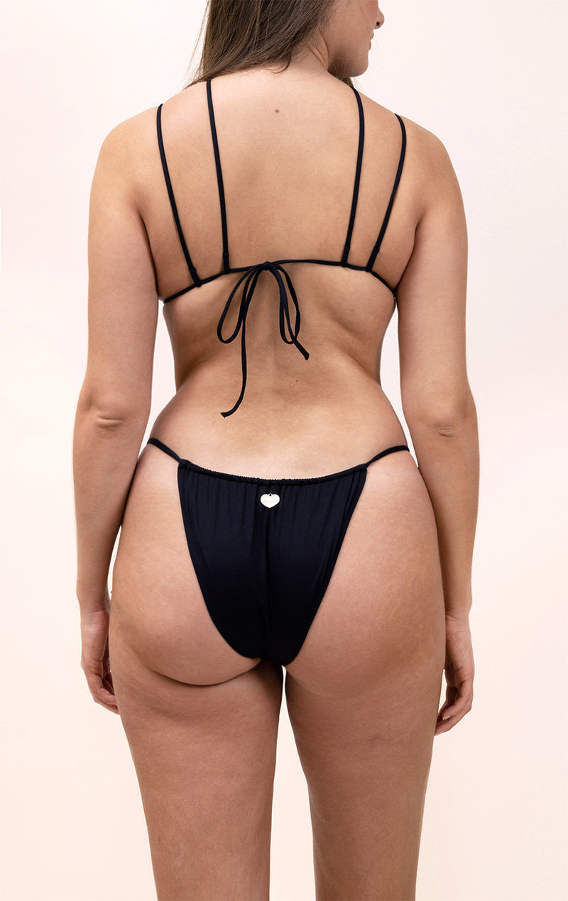 Photo d'une femme de dos portant le haut de maillot de bain Remini en noir