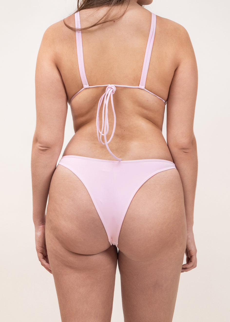 Photo de dos d'une femme portant le haut de maillot de bain Bianca de couleur rose clair (blush)