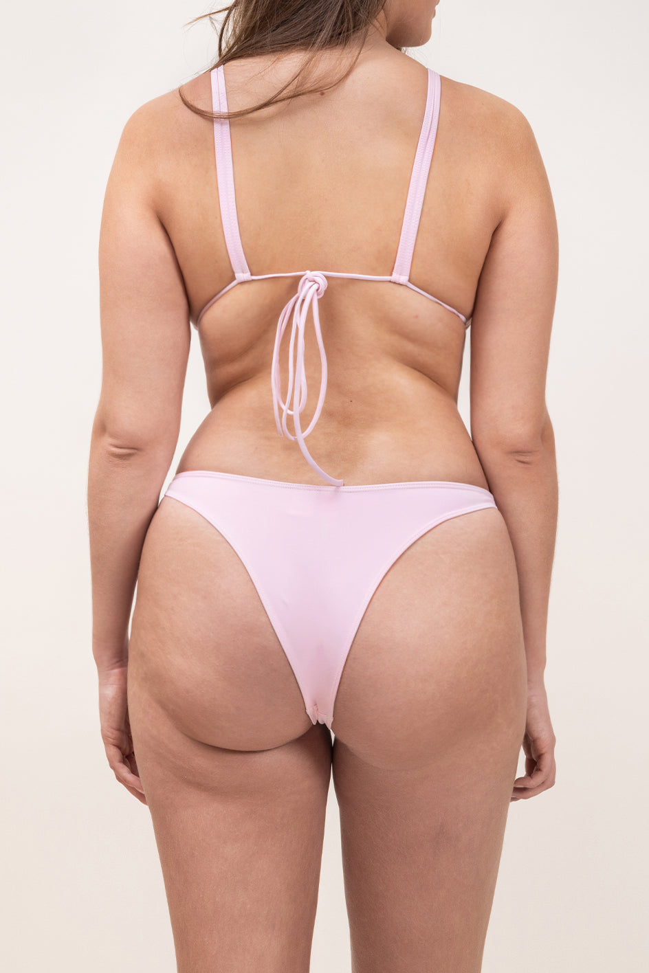 Photo de dos d'une femme portant le haut de maillot de bain Bianca de couleur rose clair (blush)