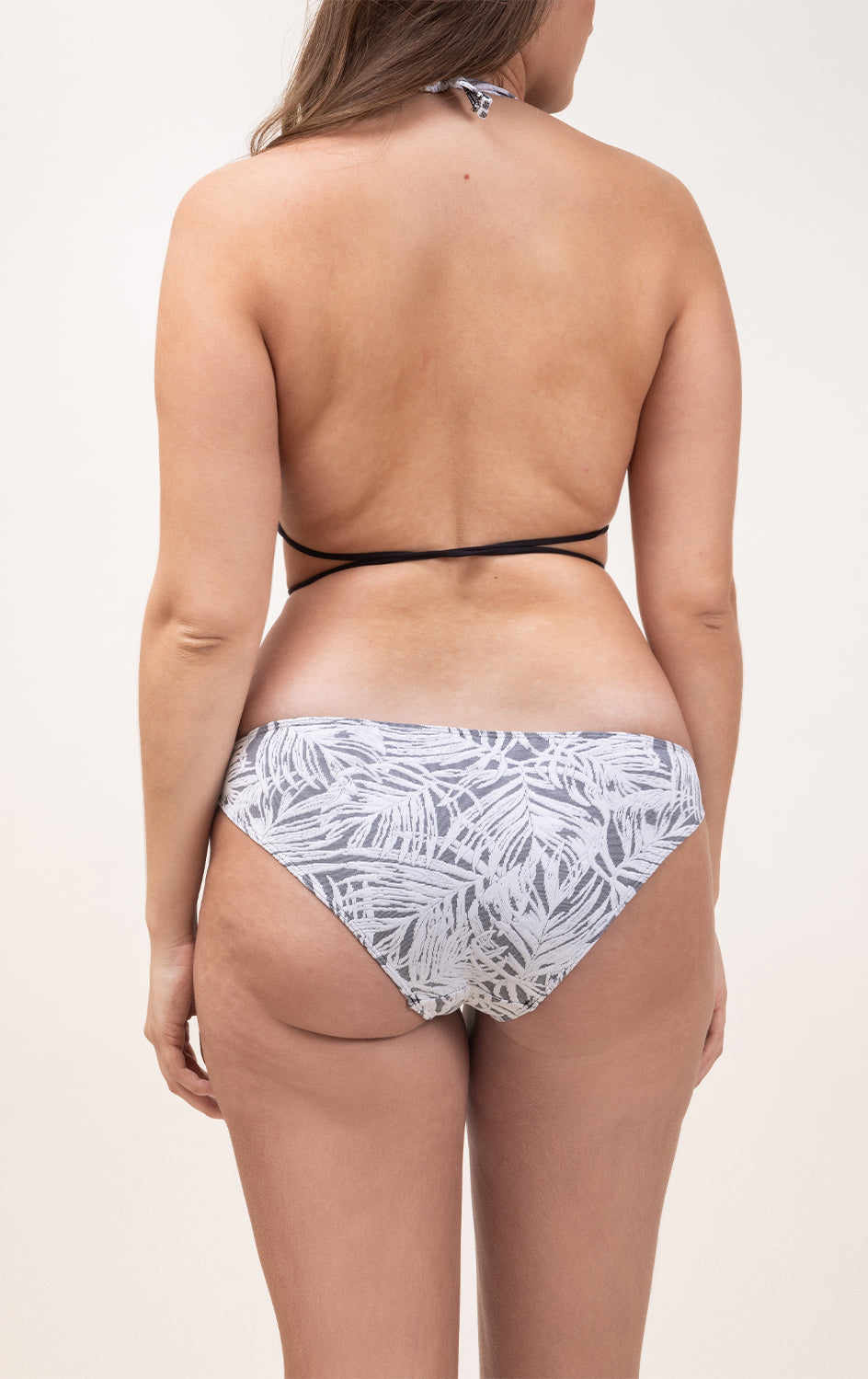 Photo de dos d'une femme portant le haut de maillot de bain Bianca à motifs végétaux et en matière jacquard