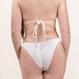 Photo d'une femme de dos portant le bas de maillot de bain Tiana en ivoire jacquard