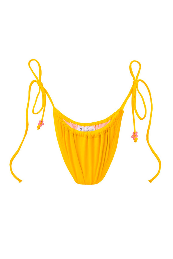 Photo détourée sur fond blanc du bas de maillot Damour jaune, avec des ficelles sur les côtés portant une perle rose en forme de fleur.