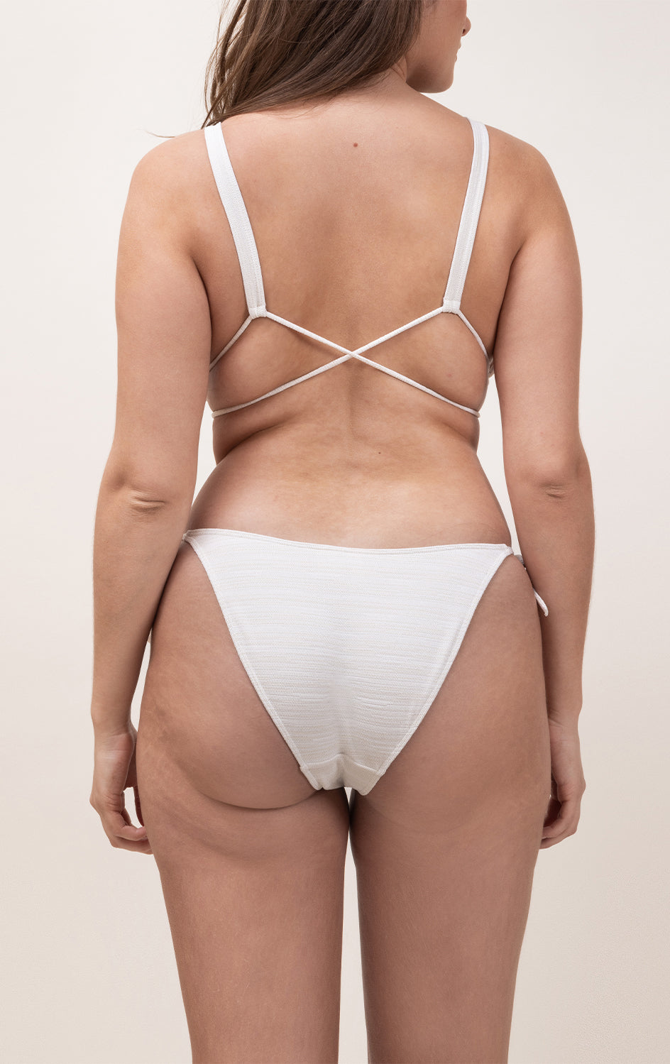 Photo d'une femme à forte poitrine de dos portant le bas de maillot de bain Monterosso ivoire jacquard