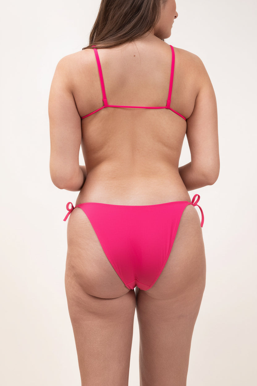 Photo d'une femme à forte poitrine de dos portant le haut de maillot de bain Ponza en rose saphire
