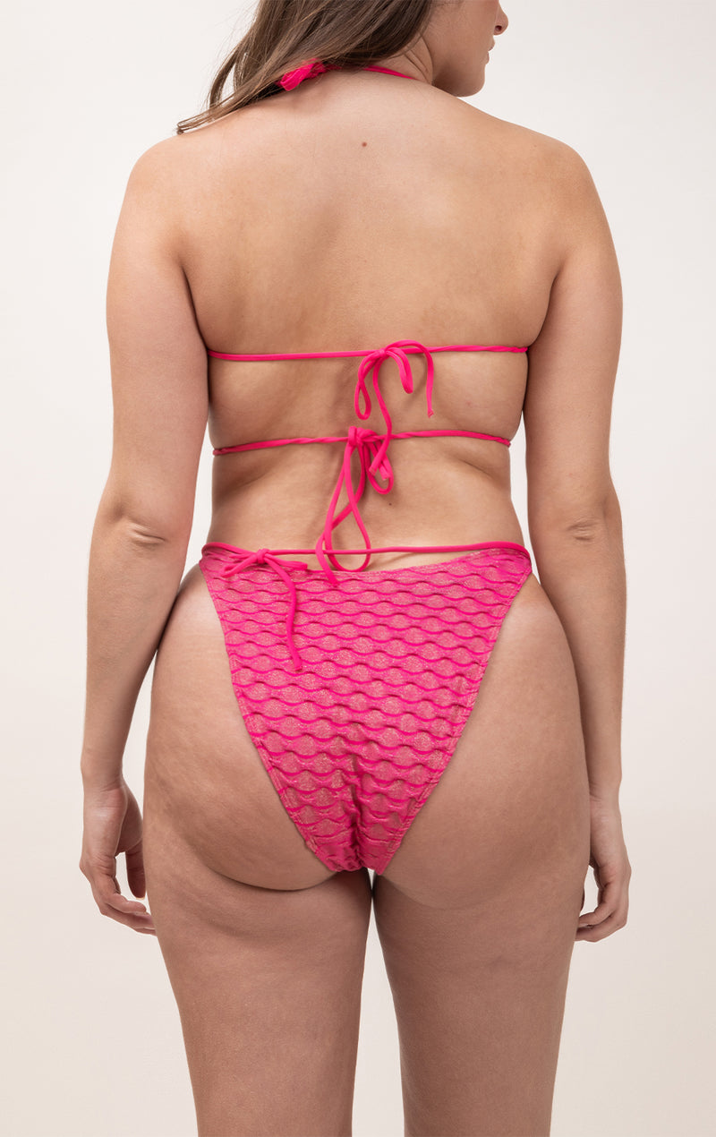 Photo d'une femme à forte poitrine de dos portant le haut de maillot de bain Ponza en fuschia/lurex
