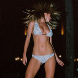 Photo d'une mannequin les cheveux au vent portant le haut de maillot de bain Bianca à motifs végétaux et en jacquard
