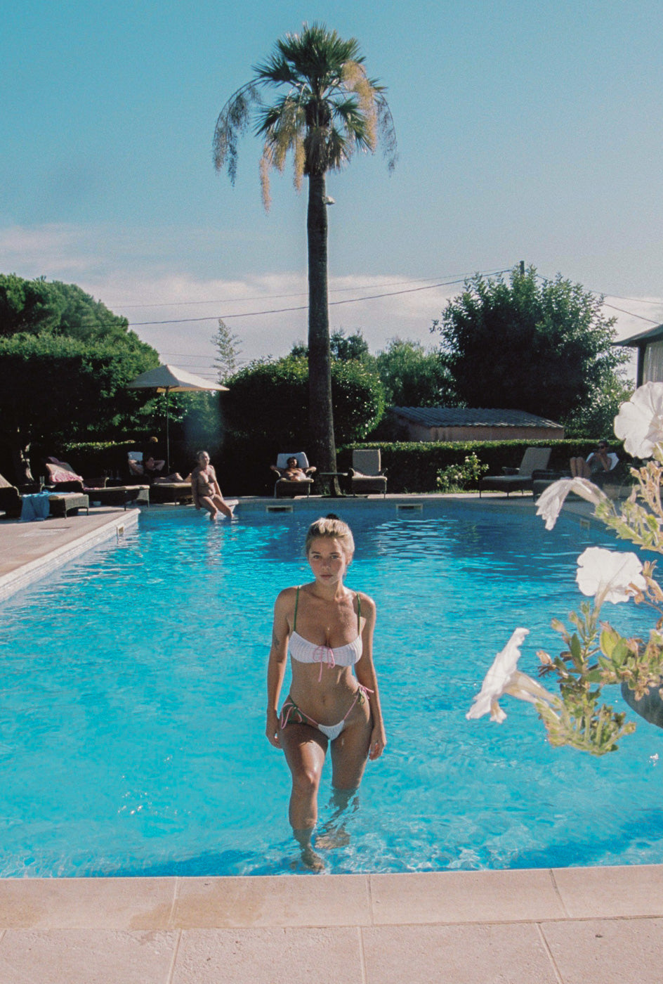 Photo d'une femme sortant d'une piscine, portant le maillot de bain Alaior blanc