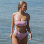 Photo d'une mannequin sortant de l'eau portant le maillot de bain une pièce Capri couleur blush