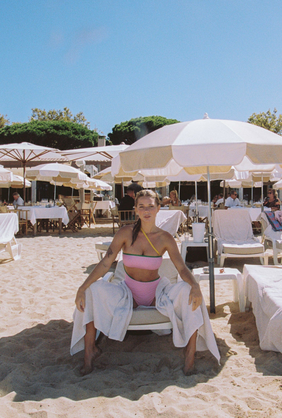 Photo d'une mannequin assise sur un transat portant le maillot de bain une pièce Capri couleur blush