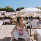 Photo d'une mannequin assise sur un transat portant le maillot de bain une pièce Capri couleur blush