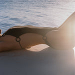 Photo d'une mannequin allongée au bord de la mer du maillot de bain une pièce Donatella noir jacquard
