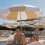 Photo d'un femme allongée à la plage portant le haut de maillot de bain Remini rose vichy