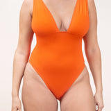Photo de face d'une femme portant le maillot de bain une pièce Saltwhitstle orange tangerine