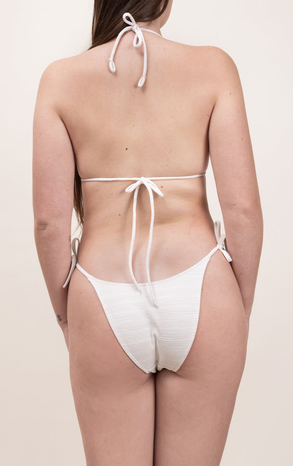 Photo de dos d'une femme portant le haut de maillot de bain Talita en blanc jacquard