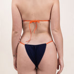 Photo de dos d'une femme portant le haut de maillot de bain Talita en tangerine et matière éponge