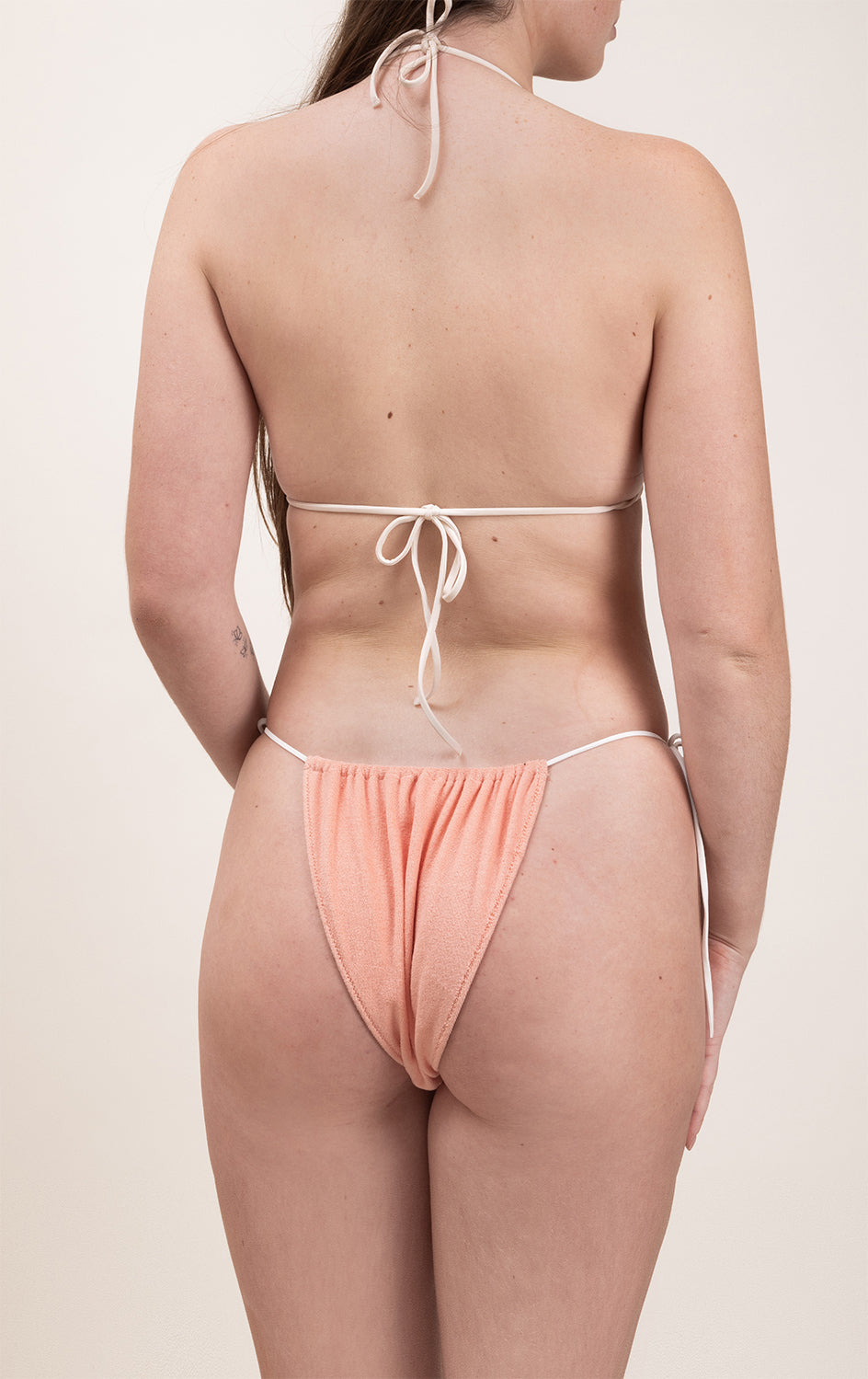 Photo de dos d'une femme portant le haut de maillot de bain Talita en beige et matière éponge