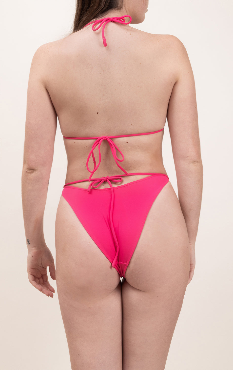 Photo d'une femme portant le haut de maillot de bain Lucia rose saphire, en matière éponge, de dos