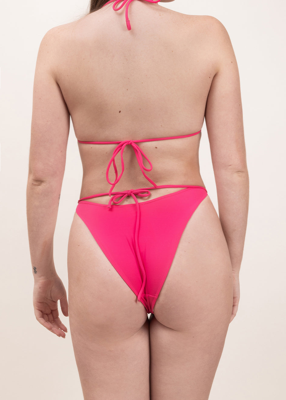 Photo d'une femme de dos portant le bas de maillot de bain Tiana en rose saphire